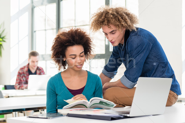 Stock photo: Two friendly classmates of different nationalities talking about