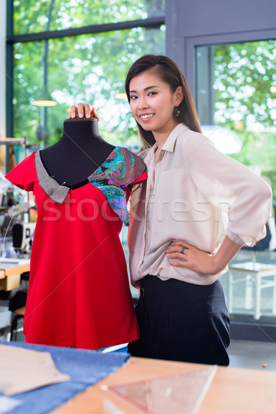 Asian tailor adjusts garment design on mannequin Stock photo © Kzenon