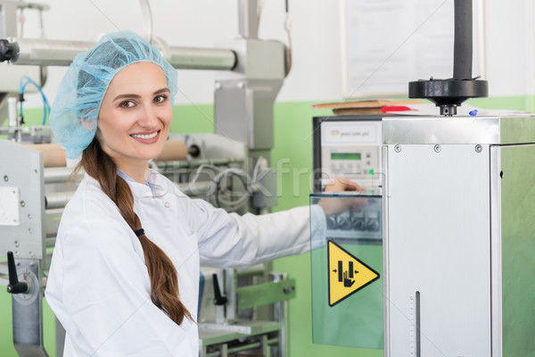 Woman manufacturing engineer adjusting the settings of an industrial machine Stock photo © Kzenon