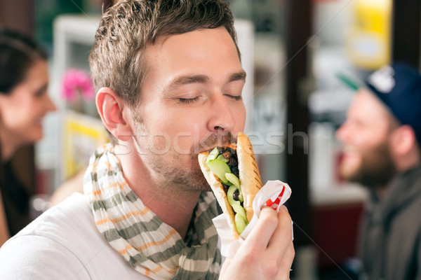 Customer eating Hotdog in fast food snack bar Stock photo © Kzenon