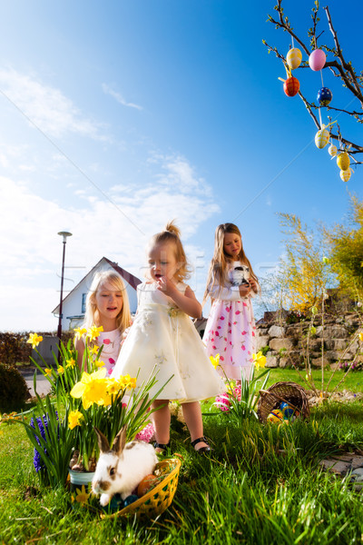 Children on Easter egg hunt with bunny Stock photo © Kzenon