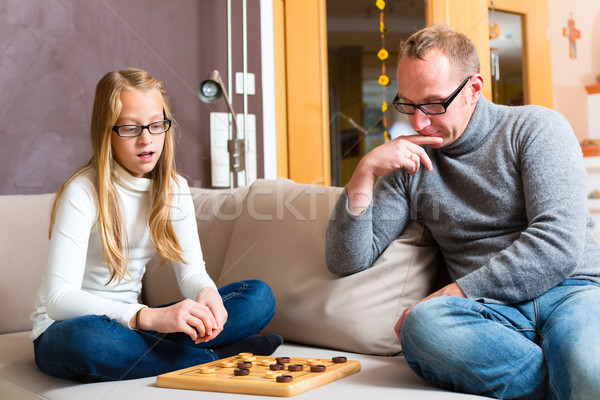 Stock photo: Father and daughter playing checkers