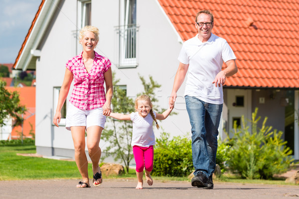 Family taking walk in front of home Stock photo © Kzenon