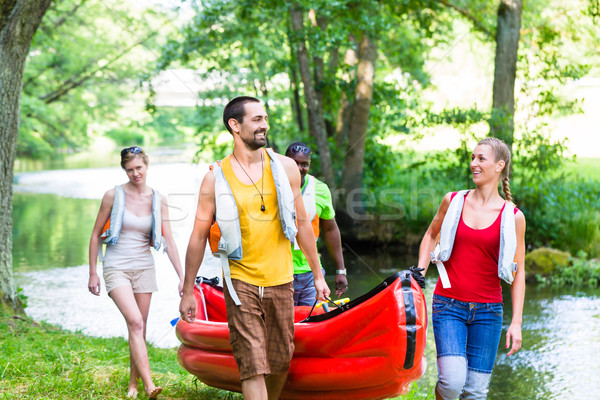 Friends carrying kayak or canoe to forest river Stock photo © Kzenon
