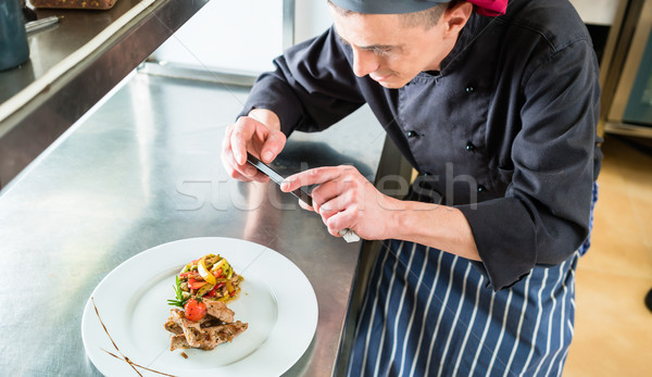 Stock photo: Chef making picture of food he cooked with phone