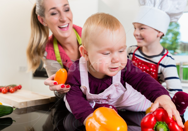 Mum and two children cooking together in kitchen Stock photo © Kzenon