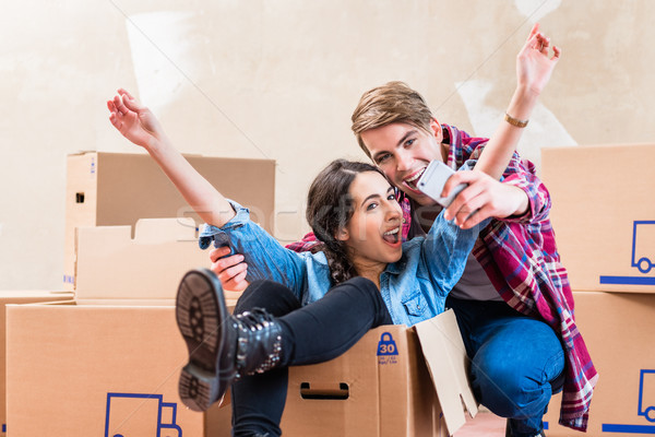Stock photo: Happy young man and woman making a selfie after moving in into a