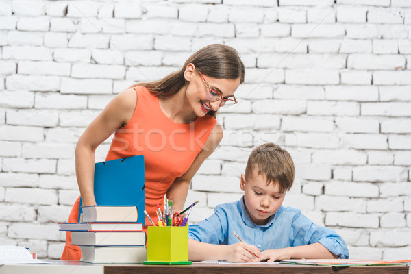 Mother helping her son to do the school homework Stock photo © Kzenon