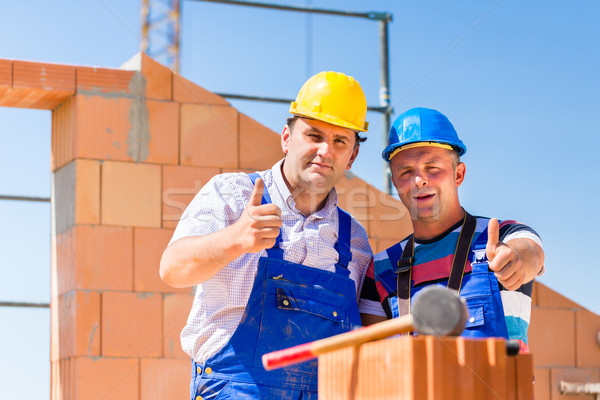 Construction site workers building walls on house Stock photo © Kzenon