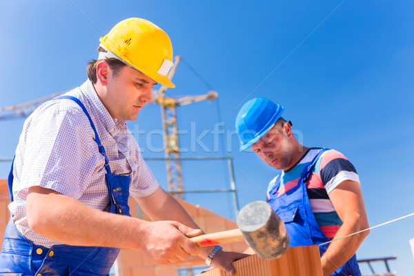 Construction site workers building walls on house Stock photo © Kzenon