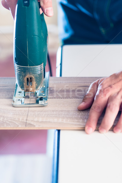 DIY worker cutting wooden panel with jig saw Stock photo © Kzenon