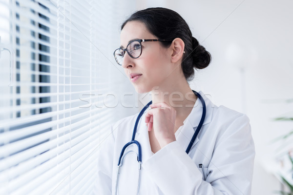 Jungen weiblichen Arzt Träumerei schauen Fenster Stock foto © Kzenon