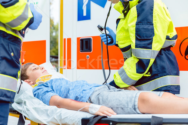 Emergency doctors putting injured boy in ambulance Stock photo © Kzenon