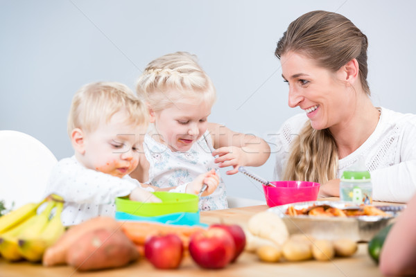 Portret fericit mamă doua copii şedinţei Imagine de stoc © Kzenon