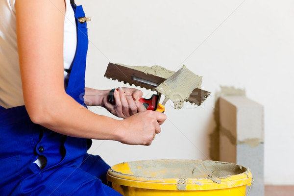 Female tiler tiling tiles on the floor Stock photo © Kzenon