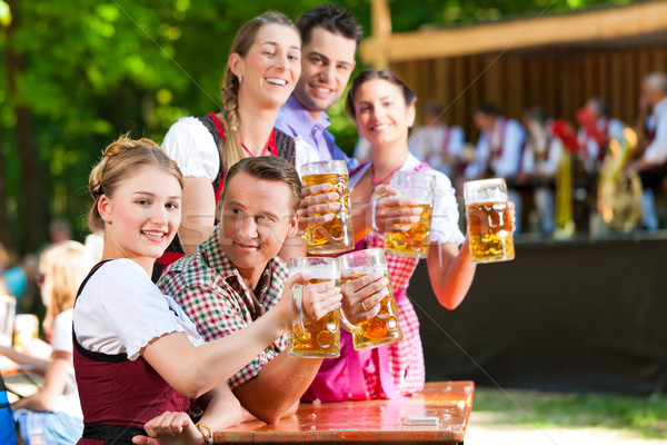 In Beer garden - friends in front of band Stock photo © Kzenon