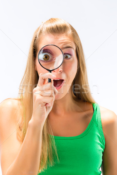 Woman looking through magnifying glass or loupe Stock photo © Kzenon