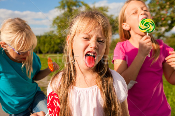 Three girls eating lollypops Stock photo © Kzenon