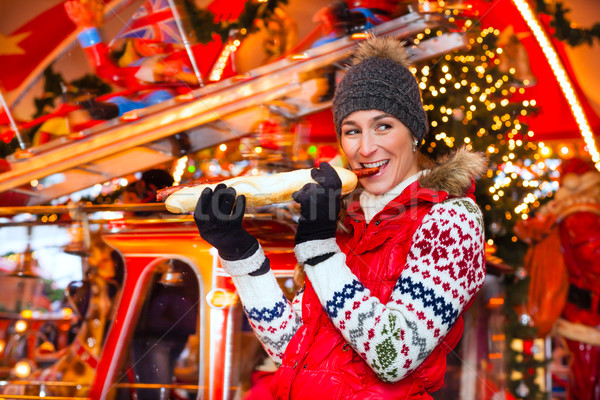 Woman eating grilled sausage on Christmas market Stock photo © Kzenon