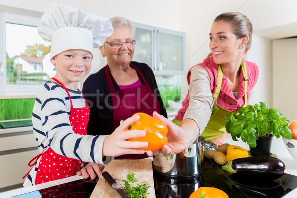 Granny, mum and son talking while cooking in kitchen Stock photo © Kzenon