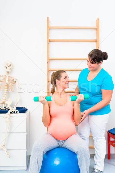 Pregnant woman working out with dumbbells in physical therapy Stock photo © Kzenon