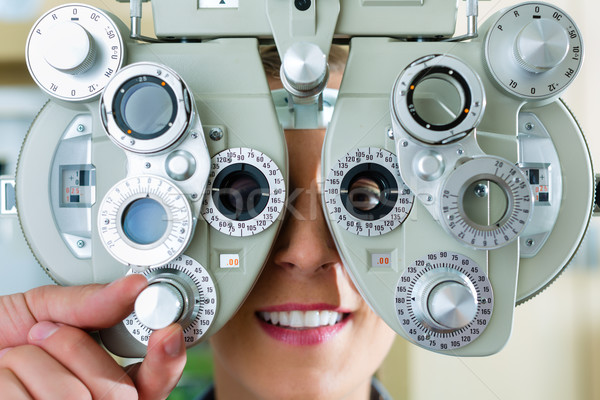 Stock photo: Young woman at phoropter for eye test
