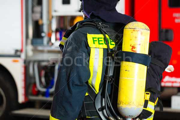 young fireman in uniform in front of firetruck Stock photo © Kzenon