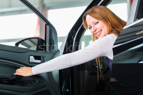 Young woman in seat of auto in car dealership Stock photo © Kzenon