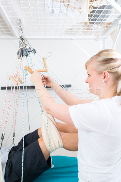 Stock photo: Physiotherapist with patient on sling table  