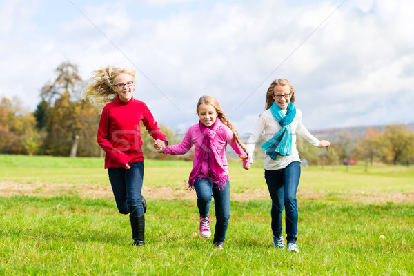 Girls running through fall or autumn park Stock photo © Kzenon