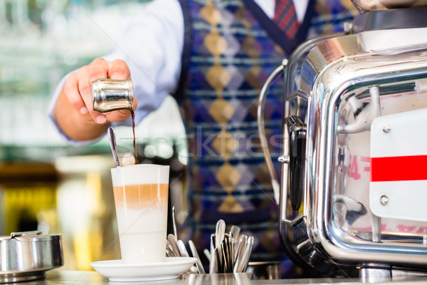 Barista in cafe pouring espresso shot in latte macchiato Stock photo © Kzenon