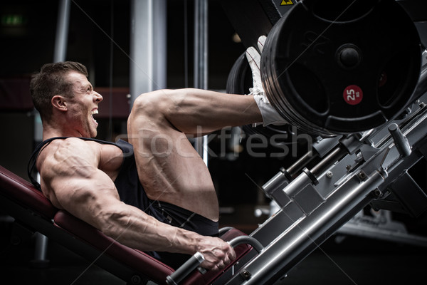 Człowiek siłowni szkolenia nogi naciśnij mięśni Zdjęcia stock © Kzenon