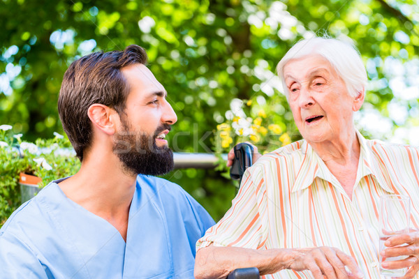 Nurse having chat with senior woman in nursing home Stock photo © Kzenon