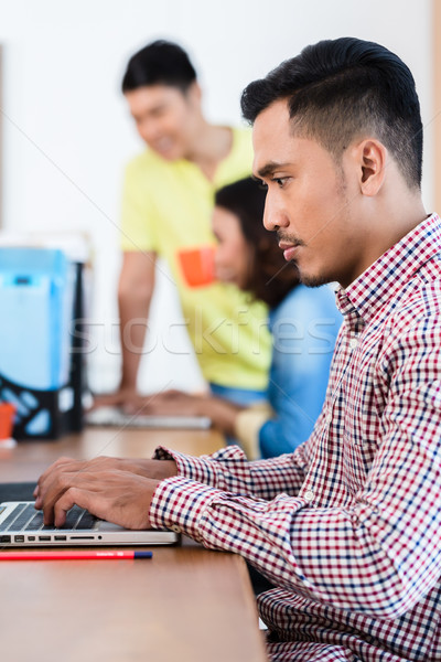 Tineri dedicat asiatic expert lucru laptop Imagine de stoc © Kzenon