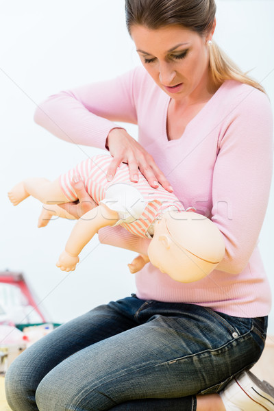 Woman in first aid course practicing revival of infant on baby d Stock photo © Kzenon