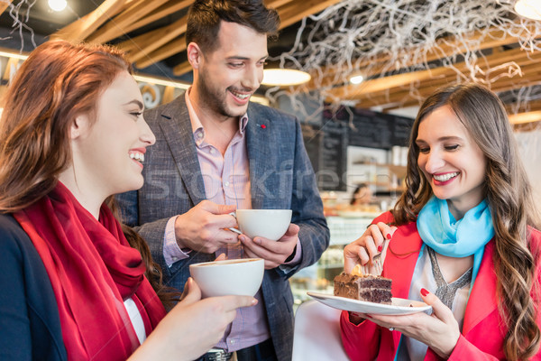 Attractive young woman meeting an old friend while enjoying a hot drink Stock photo © Kzenon