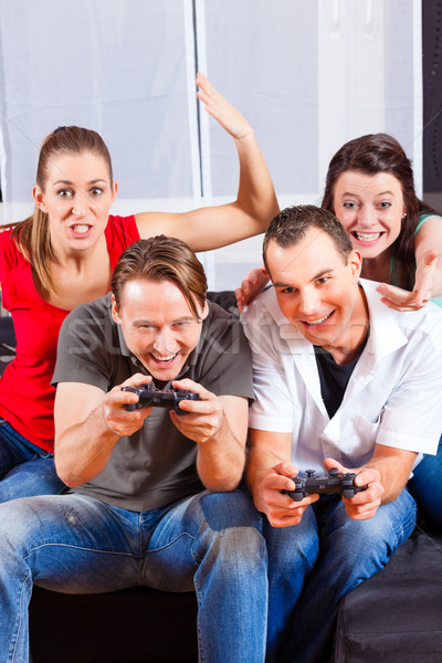 Friends sitting in front of game console box Stock photo © Kzenon