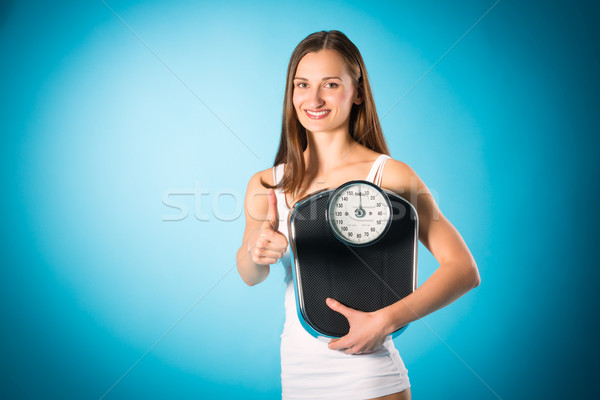 Losing weight - Young woman with measuring scale Stock photo © Kzenon