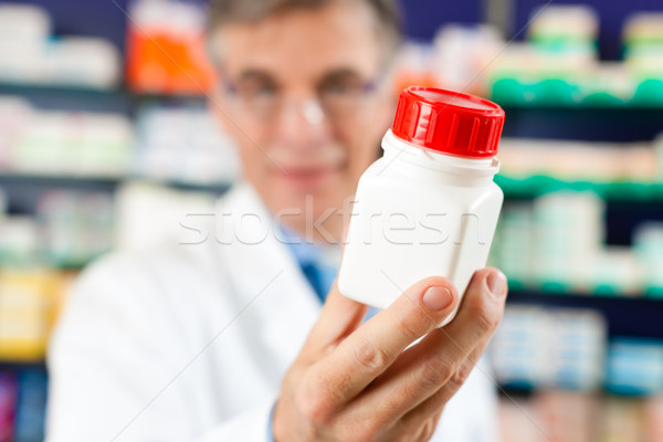 Pharmacist in pharmacy with medicament Stock photo © Kzenon
