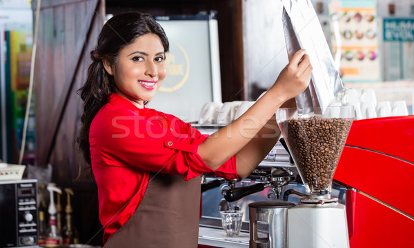 Indian barista filling coffee grinder Stock photo © Kzenon