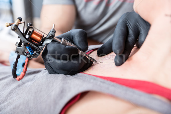 Close-up of the hands of a skilled artist making the contour of a tattoo Stock photo © Kzenon