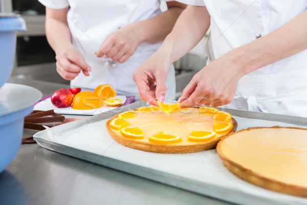 Fruit cakes being made by two pastry bakers Stock photo © Kzenon