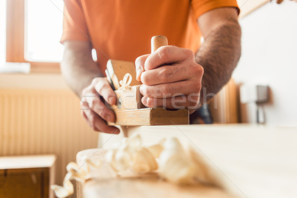 Young Carpenter working with wood planer Stock photo © Kzenon