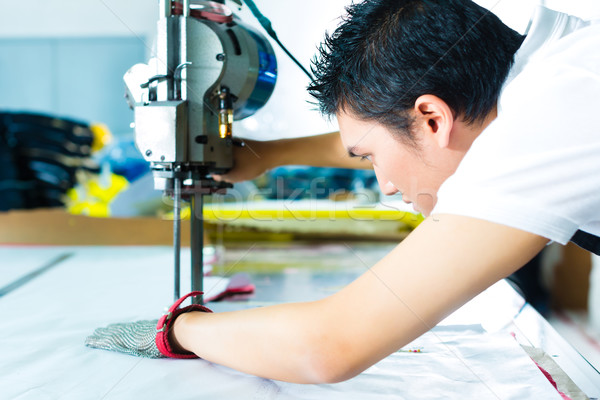 Worker using a machine in chinese factory Stock photo © Kzenon