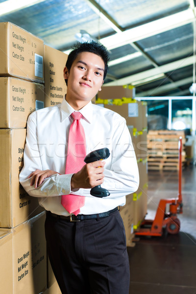 Young Man in a warehouse with Scanner Stock photo © Kzenon