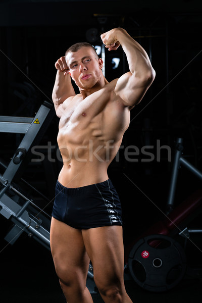Bodybuilder posing in Gym Stock photo © Kzenon
