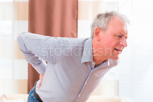 Senior having back pain at home Stock photo © Kzenon