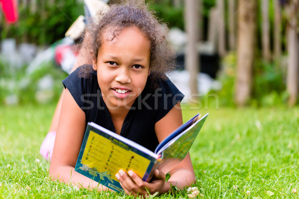 Black girl reading book on meadow Stock photo © Kzenon
