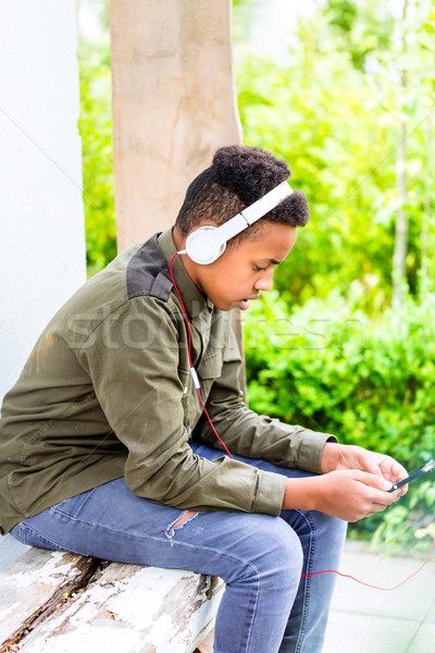 Black boy listening to music with headphones Stock photo © Kzenon