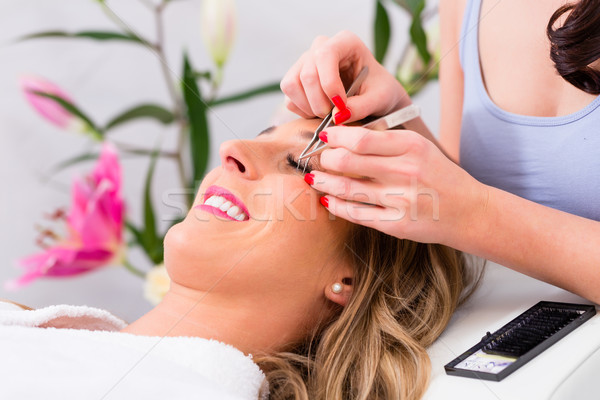 Woman receiving false eye lashes in beauty studio Stock photo © Kzenon